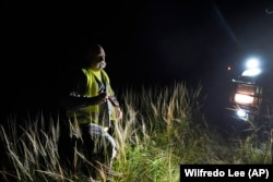 Thomas Aycock, a contractor with the Florida Fish and Wildlife Conservation Commission, heads back to his truck after checking out a marker along a levy as he searches for invasive Burmese pythons, Tuesday, Aug. 13, 2024, in the Florida Everglades. (AP Photo/Wilfredo Lee)