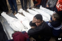 Palestinians mourn relatives killed in an Israeli bombardment of the Gaza Strip outside a morgue in Khan Younis on Jan. 4, 2024.