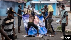 Wafuasi wa upinzani wakiiharibu picha ya rais aliye madarakani Azali Assoumani huko Moroni Januari 17, 2024. Picha na Olympia de Maismont/ AFP.