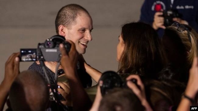 Former prisoner Evan Gershkovich greets Wall Street Journal Editor-in-Chief Emma Tucker as he arrives at Joint Base Andrews in Maryland on Aug. 1, 2024.