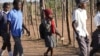 FILE - Esther Bote, 14, walks to school with her friends on the periphery of Save Valley Conservancy, Zimbabwe, on July 10, 2024.