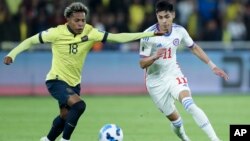 El chileno Darío Osorio, derecha, y el ecuatoriano Joao Ortiz luchan por el balón durante un partido de fútbol de clasificación para la Copa Mundial de la FIFA 2026 en el estadio Rodrigo Paz Delgado en Quito, Ecuador, el martes 21 de noviembre de 2023.