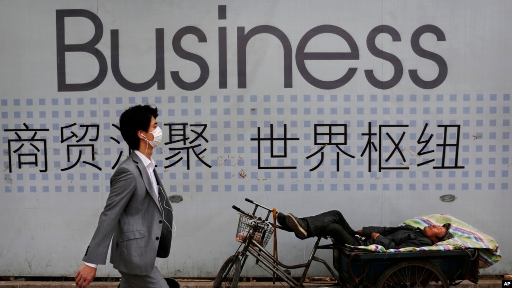 资料照 - 一位中国拉三轮工人在他的三轮车上休息。背景是一招商广告。(photo:VOA)