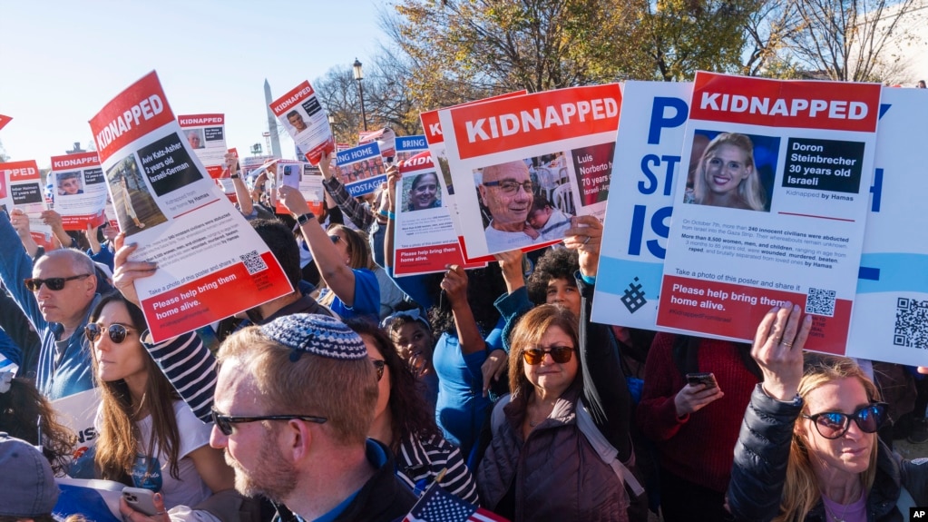 2023年11月14日，参加在华盛顿国家大草坪举行的支持以色列的游行集会的人群挥舞着带有被哈马斯绑架的人质照片的标语。（美联社照片）(photo:VOA)