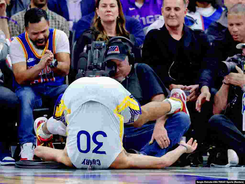 Golden State Warriors guard Stephen Curry (30) is flipped upside down after a play during the second quarter against the Sacramento Kings at Golden 1 Center in Sacramento, California, Nov. 28, 2023.