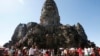 FILE - Tourists line up for stepping up Angkor Wat temple outside Siem Reap, Cambodia, Dec. 31, 2017.