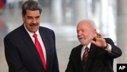 Prezidan Brezilyen Luiz Inacio Lula da Silva ( a dwat) bay Prezidan Venezyelyen Nicolas Maduro lanmen, anvan yon rankont bilateral nan pale Planalto a nan Brasilia, kapital Brezil, 29 Me, 2023. 