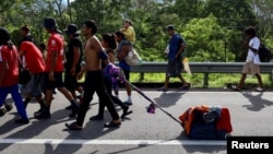 Migrantes caminan en caravana hacia la frontera con Estados Unidos, en Villa Comaltitlán, México, el 25 de julio de 2024.