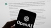 FILE - The OpenAI logo is seen on a mobile phone in front of a computer screen displaying output from ChatGPT. Experts say artificial intelligence will make investigative journalism easier, especially for smaller newsrooms.