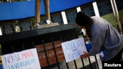 Seorang jurnalis menaruh poster dalam aksi protes yang menuntut keadilan atas tewasnya wartawan foto Ismael Villagomez Tapia dalam aksi di Plaza del Periodista di Ciudad Juarez, Meksiko, pada 17 November 2023. (Foto: Reuters/Jose Luiz Gonzalez)