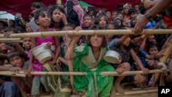 FILE - Rohingya Muslim children refugees, who crossed over from Myanmar into Bangladesh, wait to receive food handouts distributed to children and women by a Turkish aid agency, Oct. 21, 2017, at Thaingkhali refugee camp, Bangladesh.