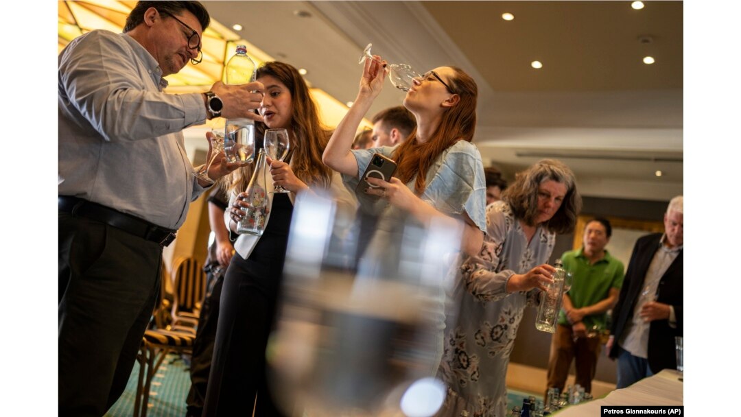 People sample glasses of fine water during an international water tasting competition held in Athens, Greece, on Wednesday, April 26, 2023. (AP Photo/Petros Giannakouris)
