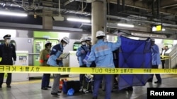 A person who is believed to have been stabbed on the Yamanote loop train line is transported by ambulance members at JR Akihabara Station in Tokyo, Japan, Jan. 3, 2024, in this photo released by Kyodo. 