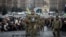 People kneel as soldiers carry the coffin of Ukrainian serviceman and poet Maksym Kryvtsov — who was killed in a battle with Russian troops — during the funeral ceremony for Kryvtsov in St. Michael Cathedral in Kyiv, Ukraine, Jan. 11, 2024.