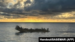 This handout photograph released on Oct. 30, 2023 by the Spanish Maritime Rescue and Safety Society SASEMAR shows migrants aboard a "cayuco" wooden boat, off the coast of the Canary island of Tenerife. 
