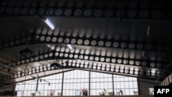 FILE - Workers watch as a delegation of ministers and ambassadors visit the construction site of the "Jeux de la Francophonie 2023" facilities in Kinshasa, Democratic Republic of Congo, on July 20, 2023. 