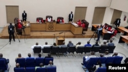 Moussa Dadis Camara, et d'autres coaccusés entrent dans la salle d'audience avant l’annonce du verdict lors du procès du massacre du stade en 2009 à Conakry, en Guinée, le 31 juillet 2024.