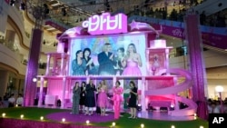 A screen shows America Ferrera, L, director Greta Gerwig, center, and Margot Robbie, R, during the pink carpet event for the movie "Barbie" in Seoul, South Korea, July 2, 2023. Vietnam's state media have reported that the government banned distribution of the popular movie.