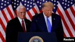 FILE - U.S. President Donald Trump and Vice President Mike Pence stand while making remarks about early results from the 2020 U.S. presidential election in the East Room of the White House in Washington, Nov. 4, 2020.