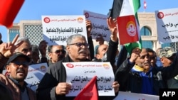 Trade unionists raise national flags and placards as they take to the streets of Tunis to protest against a proposed legislation that will grant the government sweeping powers over NGOs, on March 2, 2024.