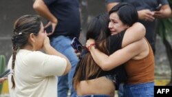 Relatives of Prosecutor Cesar Suarez weep where Suarez was shot dead in Guayaquil, Ecuador, Jan. 17, 2024. 