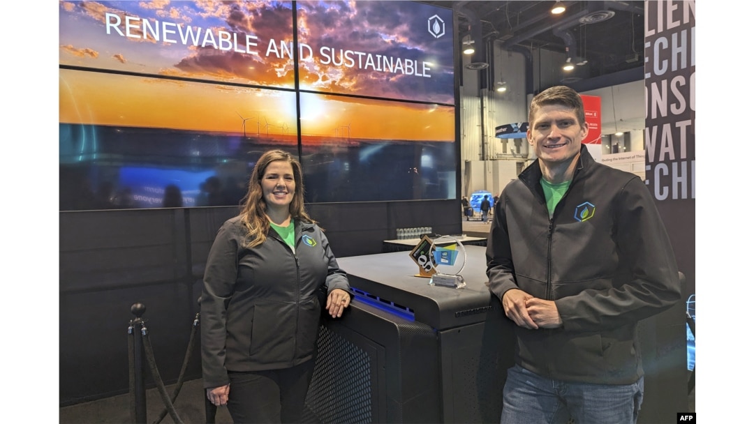 Salah satu pendiri Genesis Systems Shannon Stuckenberg (kiri) dan David Stuckenberg berpose dengan perangkat WaterCube yang mengekstraksi air dari udara selama Consumer Electronics Show (CES) di Las Vegas, Nevada, 12 Januari 2024. (Glenn CHAPMAN / AFP)