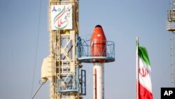 Roket Iran sebelum diluncurkan dari lokasi yang dirahasiakan ke orbit, Rabu 6 Desember 2023. Tanda di sebelah kiri bertuliskan dalam bahasa Farsi "Salman penjelajah biologis." (Kementerian Pertahanan Iran via AP)