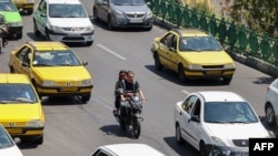 FILE - Iranian commuters drive in the capital, Tehran, on Aug. 13, 2022. Government workers are having to begin their commutes much earlier now, thanks to a revision in schedules aimed at reducing energy consumption when power consumption peaks.