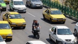 FILE - Iranian commuters drive in the capital, Tehran, on Aug. 13, 2022. Government workers are having to begin their commutes much earlier now, thanks to a revision in schedules aimed at reducing energy consumption when power consumption peaks.