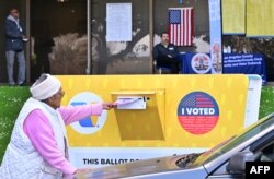 Seorang perempuan memasukkan surat suaranya ke dalam kotak suara di wilayah Panitera Los Angeles, Norwalk, California, 4 Maret 2024, menjelang pemilihan "Super Tuesday", 5 Maret. (Frederic J. BROWN / AFP)