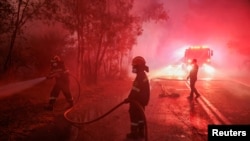 Para petugas pemadam kebakaran berupaya memadamkan api yang melahap wilayah Dionysos, Yunani, pada 12 Agustus 2024. (Foto: Reuters/Alexandros Avramidis)