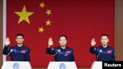 三名中国宇航员在酒泉卫星发射中心出席记者会。（2023年5月29日）