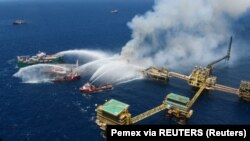 Penyemprotan air ke anjungan minyak lepas pantai yang terbakar di Lapangan Cantarell Pemex, di Teluk Campeche, Teluk Meksiko, Meksiko 7 Juli 2023. (Foto: Courtesy/Pemex via REUTERS)