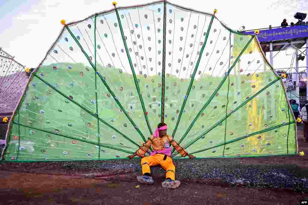 Seorang pria beristirahat setelah menampilkan tarian tradisional dalam upacara di festival Tazaungdaing, juga dikenal sebagai Festival Cahaya, di Taunggyi di Negara Bagian Shan, Myanmar, 21 November 2023.