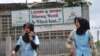 FILE - Dua perempuan Muslim berjalan melewati spanduk bertuliskan 'homoseksual dan lesbian dilarang memasuki lingkungan kami' di Bandung, Jawa Barat. (Foto: AFP/Timur Matahari)