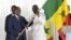 Le capitaine sénégalais Kalidou Koulibaly (à droite) reçoit le drapeau national sénégalais des mains du président sénégalais Macky Sall (à gauche), à Dakar, le 9 janvier 2024, avant le départ de l'équipe pour la Côte d'Ivoire. (Photo Seyllou / AFP)