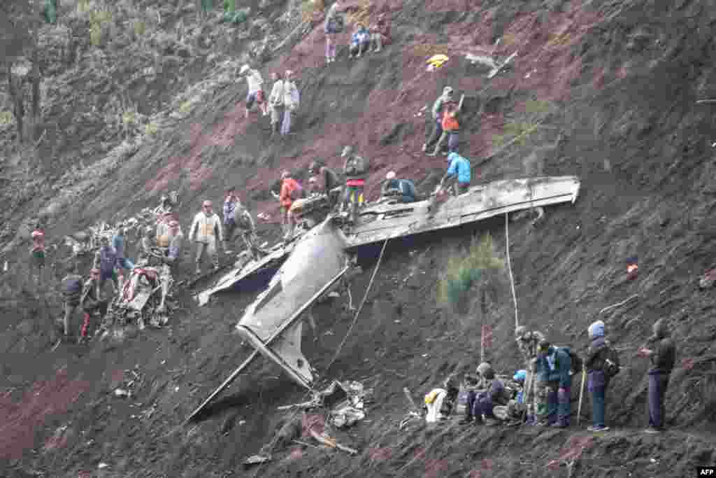 People inspect the wreckage of an Indonesia&#39;s Air Force EMB-314 Super Tucano plane that crashed in Pasuruan, East Java.&nbsp;Four people, including two pilots, were killed in Indonesia on November 16 when two military aircraft crashed into a mountainside during training, an air force spokesperson said.&nbsp;