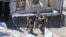 Members of the Palestinian Fatah group run to take position during a third day of clashes that erupted with Islamist factions in the Palestinian refugee camp of Ein el-Hilweh near the southern port city of Sidon, Lebanon, July 31, 2023.