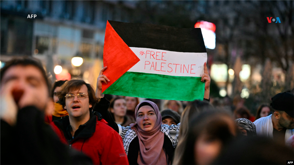 Una mujer sostiene la bandera palestina que tiene escrito: &quot;Palestina libre&quot;, durante una manifestación en apoyo del pueblo palestino en Belgrado, capital de Serbia.