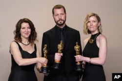 Raney Aronson-Rath, from left, Mstyslav Chernov, and Michelle Mizner pose in the press room with the award for best documentary feature film for "20 Days in Mariupol." (Photo by Jordan Strauss/Invision/AP)