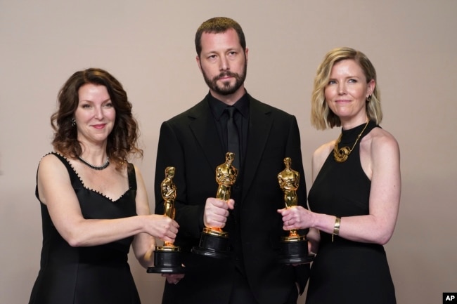 Raney Aronson-Rath, from left, Mstyslav Chernov, and Michelle Mizner pose in the press room with the award for best documentary feature film for "20 Days in Mariupol." (Photo by Jordan Strauss/Invision/AP)