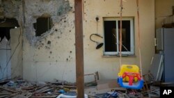 Una mecedora de niño se ve en medio de la destrucción de lo que sería una casa en un kibutz , donde la milicia de Hamás arremetió contra israelíes.