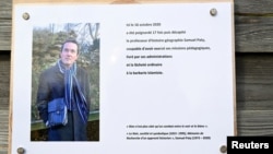 Plakat dengan foto almarhum guru Samuel Paty dalam rangka memperingati terbunuhnya guru tersebut di dekat sekolah Bois d'Aulne, Conflans-Sainte-Honorine, di luar Paris. (BERTRAND GUAY/Pool via REUTERS)