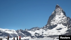 FILE - Tourists take a picture in front of the Matterhorn mountain at the Gornergrat in Zermatt, Switzerland June 2, 2019.