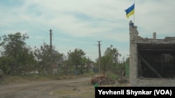 A Ukrainian flag flies on a burnt-out store in a village recently recaptured by Ukraine in Storozheve, Ukraine, June 23, 2023.