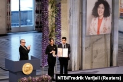Ali and Kiana Rahmani, children of Narges Mohammadi, an imprisoned Iranian human rights activist, hold the Nobel Peace Prize 2023 award, accepting it on behalf of their mother at Oslo City Hall, Norway, Dec. 10, 2023.