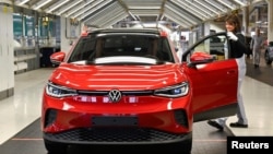 资料照：德国茲威考大众汽车厂的一名技师在检查一辆即将出厂的大众ID.4型电动汽车。（2022年4月26日）