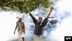 Kenyan activists shout amidst teargas during a protest over tax hike plans in Nairobi on June 6, 2023. 