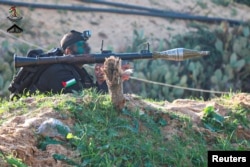 Pripadnik združenih snaga palestinskog otpora, u čijem je sastavu i Hamas, stoji u rovu držeći bacač protivtenkovskih granata, na poligonu na nepoznatoj lokaciji, na fotografiji objavljenoj na društvenim mrežama 28. decembra 2022.