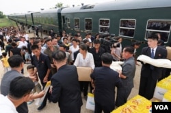 수해 피해를 입은 평안북도 의주군 거주민들이 '대성백화점'의 이름이 새겨진 쇼핑백과 지원용으로 보이는 물품을 받고 있다. (사진출처: 조선중앙통신)